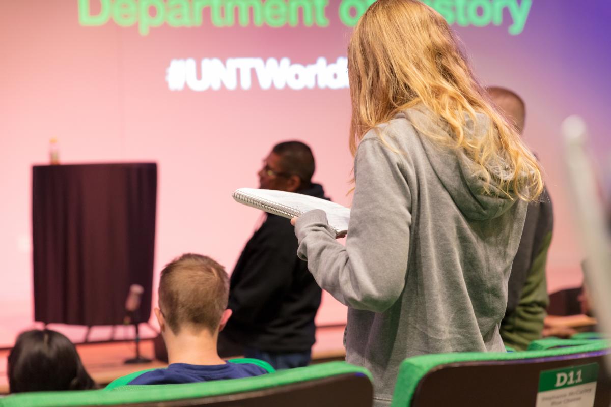 people standing and sitting in chairs