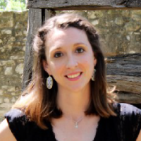 headshot of a smiling woman with black and blue text