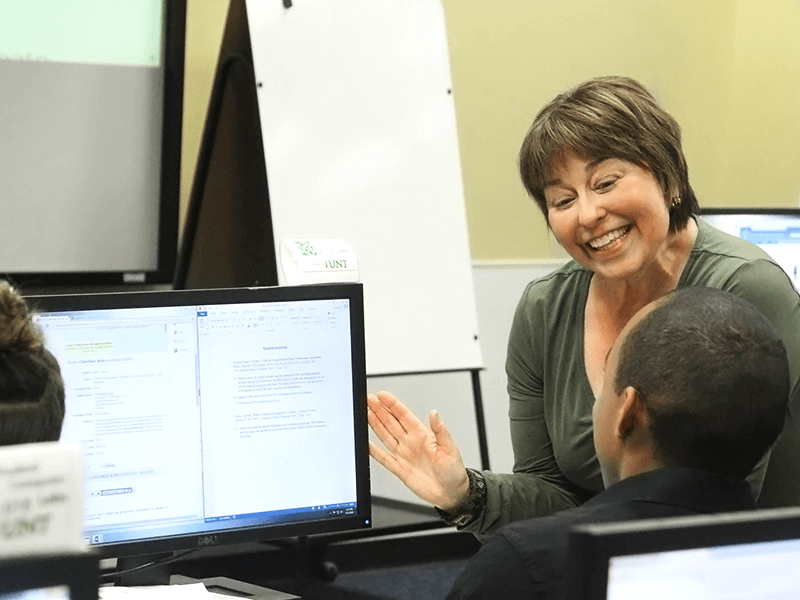 smiling woman and man at a computer