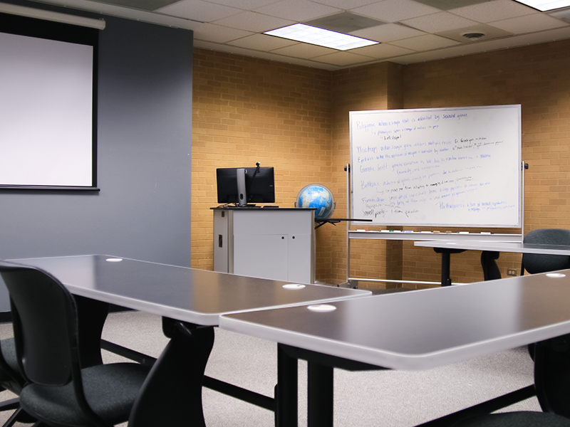 presentation station and screen with tables, chairs, and a mobile whiteboard